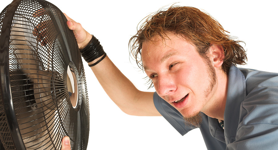 Man inspecting a large fan, demonstrating the importance of air circulation and cooling in HVAC systems.