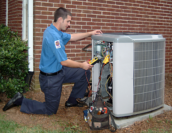 HVAC technician servicing an air conditioning unit, utilizing tools and equipment for maintenance and repair.