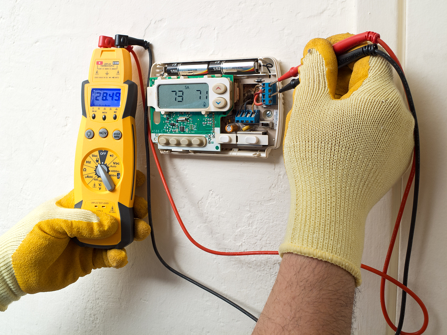 Technician checking thermostat.