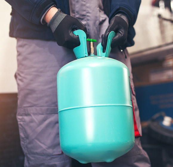 Man holding container of refrigerant.
